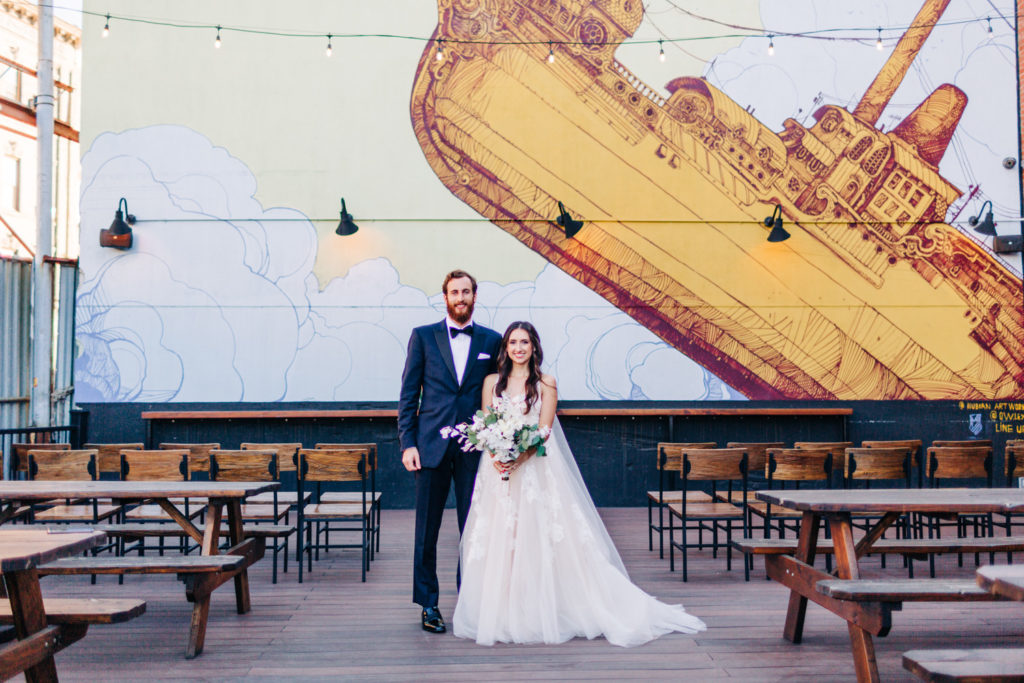 bride and groom portrait in front of mural